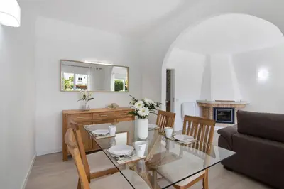 a dining room and living room with a glass table at Villa Janeca in Albufeira