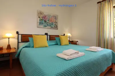 a bedroom with a blue bed with towels on it at São Rafael - Hydrangea 5, Apt. T2 - Albufeira in Albufeira