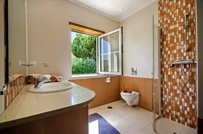 a bathroom with a sink and a shower and a toilet at Villa Palm Golfe, fantastic house on Vila Sol course, kids pool, aircon in Quarteira