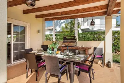 an outdoor dining room with a table and chairs at Villa Palm Golfe, fantastic house on Vila Sol course, kids pool, aircon in Quarteira