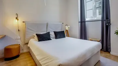 a bedroom with a large white bed with two pillows at Hostellicious Studio in Faro