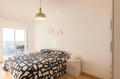 a bedroom with a black and white bed and a window at Sunset entre a Ria e o Teatro in Faro