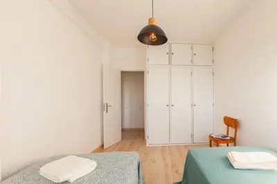 a bedroom with two beds and a white cabinet at Sunset entre a Ria e o Teatro in Faro