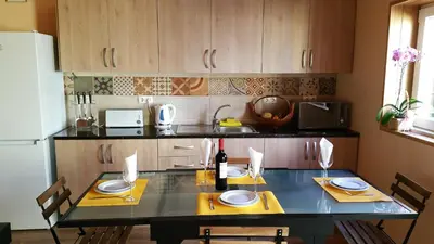 a kitchen with a table with chairs and a refrigerator at Happy House Comfort Plus in Faro