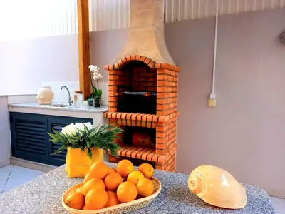 a bowl of oranges on a counter with a brick oven at Miral 1 - Apartment 100m to the beach by HD PROPERTIES - Quarteira in Quarteira