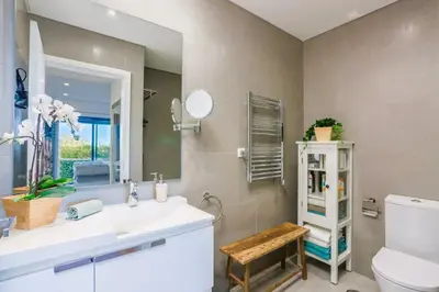 a bathroom with a sink and a toilet and a mirror at Cavalo Preto Beach Residence with Garden & Pool in Quarteira