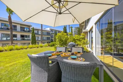 a table with an umbrella and some food on it at Cavalo Preto Beach Residence with Garden & Pool in Quarteira