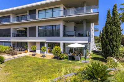 an apartment building with a lawn in front of it at Cavalo Preto Beach Residence with Garden & Pool in Quarteira