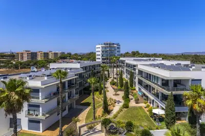 an aerial view of a building with palm trees at Cavalo Preto Beach Residence with Garden & Pool in Quarteira