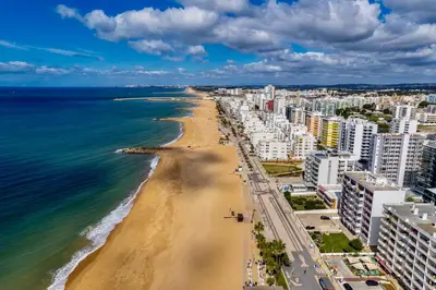 a view of a beach with buildings and the ocean at Cavalo Preto Beach Residence with Garden & Pool in Quarteira