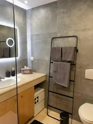 a bathroom with a towel rack and a sink at Corcovada in Albufeira