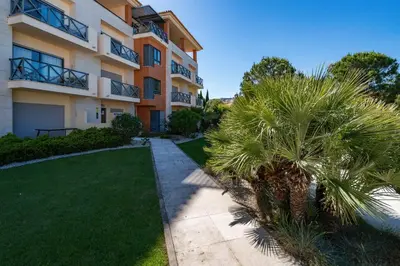 an apartment building with a palm tree in front of it at Corcovada in Albufeira