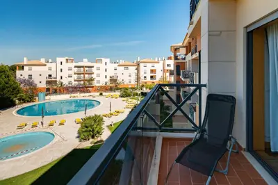 a balcony with a view of a pool and buildings at Corcovada in Albufeira