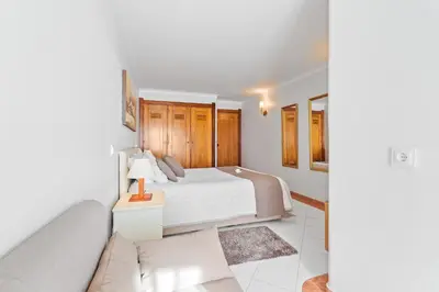 a bedroom with a bed and a couch at Duplex Sea View by Albufeira Holidays in Albufeira