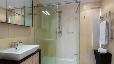 a bathroom with a sink and a glass shower at Victory Village Quinta do Lago - Spacious 2 Bed / 3 Bath Apartment in Almancil
