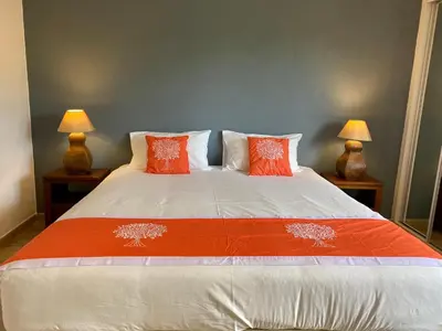 a bed with orange and white pillows and two lamps at Victory Village Quinta do Lago - Spacious 2 Bed / 3 Bath Apartment in Almancil