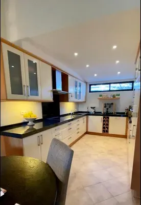 a kitchen with white cabinets and a black counter top at Victory Village Quinta do Lago - Spacious 2 Bed / 3 Bath Apartment in Almancil