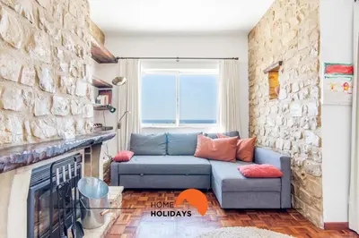 a living room with a blue couch and a stone wall at #052 V4 Mimosas by Home Holidays in Albufeira