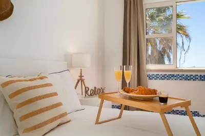 a bed with two glasses of champagne and a tray of croissants at Beach villa with ocean view and rooftop cinema in Guia