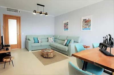 a living room with a blue couch and a table at House J São Rafael - By Bedzy in Albufeira