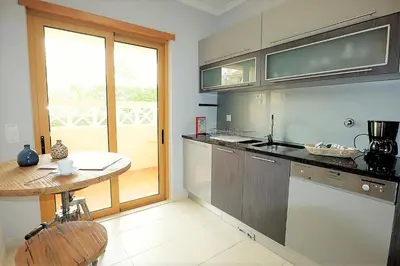 a kitchen with a table and a counter top at House J São Rafael - By Bedzy in Albufeira