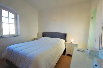 a bedroom with a bed and a desk and a window at Qta do Eucalipto Villa in Faro