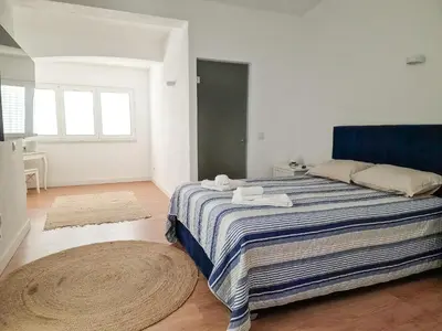 a bedroom with a bed with a striped blanket and a rug at Qta do Eucalipto Villa in Faro