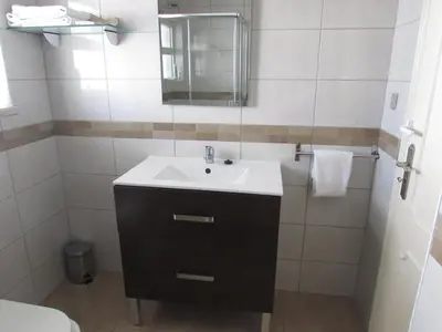 a bathroom with a sink and a mirror at Debimar Apartamentos in Albufeira