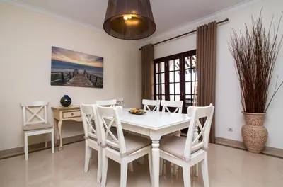 a dining room with a white table and chairs at Villa a Sul in Albufeira
