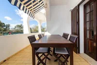 a dining room with a wooden table and chairs at Villa a Sul in Albufeira
