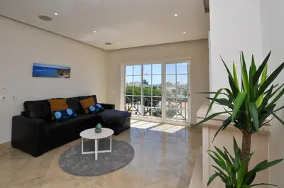 a living room with a black couch and a table at Oura Sea View by OCvillas in Albufeira