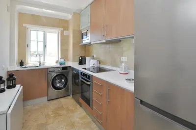 a kitchen with a washer and dryer in it at Oura Sea View by OCvillas in Albufeira