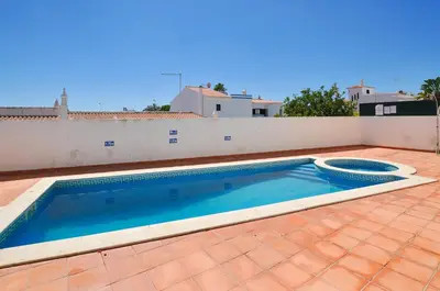 a swimming pool on a patio with a white wall at Oura Sea View by OCvillas in Albufeira