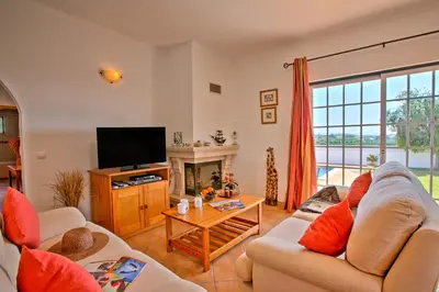a living room with two couches and a television at Villa Goia by Villa Plus in Olhos de Água
