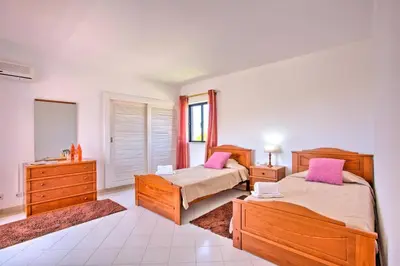a bedroom with two beds and a mirror at Villa Jorge by Villa Plus in Albufeira