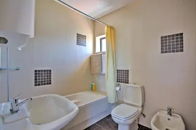 a bathroom with a sink and a toilet and a tub at Villa Jorge by Villa Plus in Albufeira