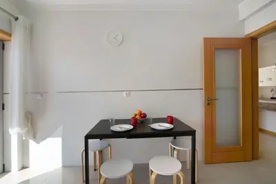a small black table with four chairs in a kitchen at Apartamento Água Brisa in Albufeira
