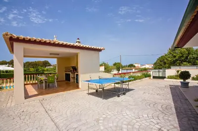 a patio with a ping pong table in front of a house at Villa Arvela by Villa Plus in Galé
