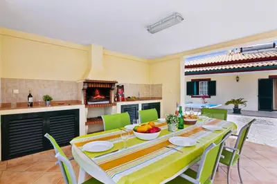a kitchen and dining room with a table and chairs at Villa Arvela by Villa Plus in Galé