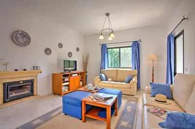 a living room with a blue couch and a fireplace at Villa Candida by Villa Plus in Vale do Lobo