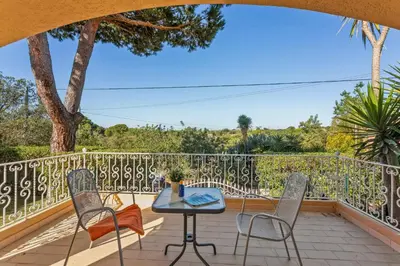 a patio with a table and chairs on a balcony at Villa Casa do Mel by Villa Plus in Loulé