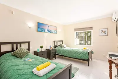 a bedroom with two beds and a window at Villa Casa do Mel by Villa Plus in Loulé
