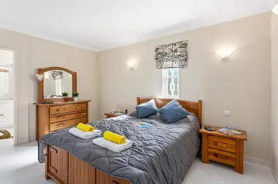 a bedroom with a bed with two pillows and a mirror at Villa Casa do Mel by Villa Plus in Loulé