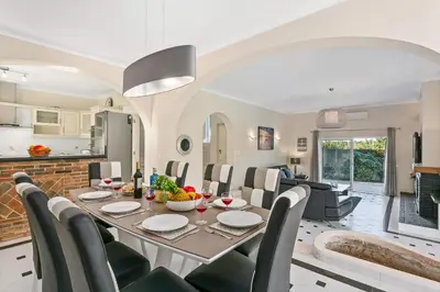 a dining room and living room with a table and chairs at Villa Casa do Mel by Villa Plus in Loulé