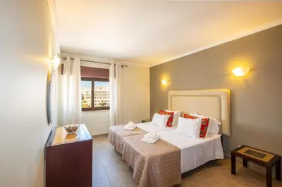 a hotel room with a table and a bed at #018 T2 Elisabete by Home Holidays in Albufeira