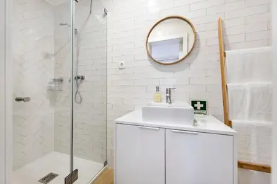 a white bathroom with a sink and a mirror at RG Studio in Faro