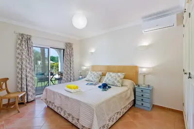a bedroom with a bed with a table on it at Villa Celia by Villa Plus in Olhos de Água