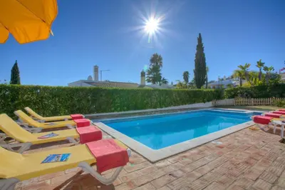a swimming pool with lounge chairs and an umbrella at Villa Flor by Villa Plus in Guia
