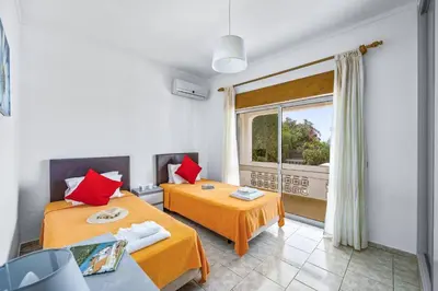 a bedroom with two beds and a large window at Villa Marrachinho by Villa Plus in Albufeira