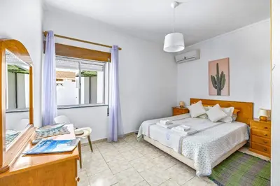 a bedroom with a bed and a desk and a window at Villa Marrachinho by Villa Plus in Albufeira